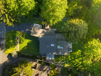 This stunning property boasts a modern architectural design, seamlessly blending with its lush, green surroundings.