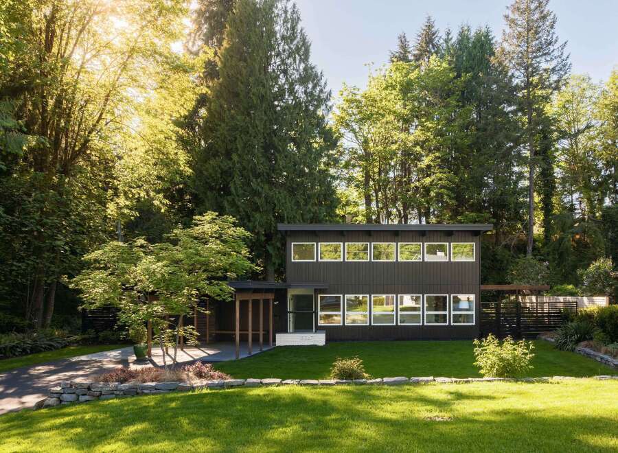 This stunning modern home offers a serene retreat surrounded by lush greenery.