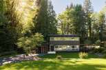 This stunning modern home offers a serene retreat surrounded by lush greenery.