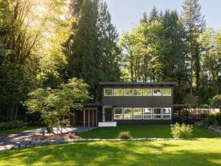 This stunning modern home offers a serene retreat surrounded by lush greenery.