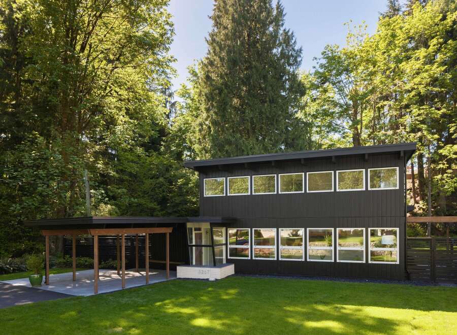 This stunning modern home boasts a sleek, dark exterior and an abundance of natural light.