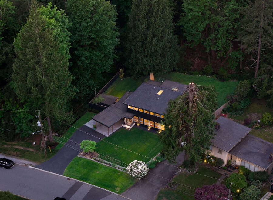 Discover a stunning modern home nestled in a lush, wooded setting.