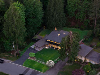 Discover a stunning modern home nestled in a lush, wooded setting.