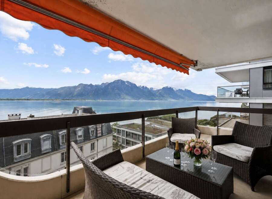 Enjoy breathtaking views from this stunning balcony overlooking a serene lake and majestic mountains.