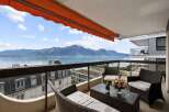 Enjoy breathtaking views from this stunning balcony overlooking a serene lake and majestic mountains.