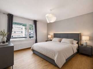 Step into this serene bedroom, featuring a modern design with a comfortable bed and stylish decor.