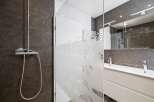 Step into a modern bathroom oasis! This stunning space features a sleek shower with a glass door, a stylish vanity, and a large mirror.