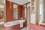 Indulge in luxury within this exquisite bathroom, featuring a stunning oval bathtub and elegant red tile accents.