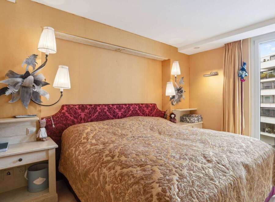 Step into a luxurious bedroom featuring a stunning bed with a unique headboard and elegant bedding.