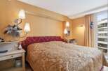 Step into a luxurious bedroom featuring a stunning bed with a unique headboard and elegant bedding.