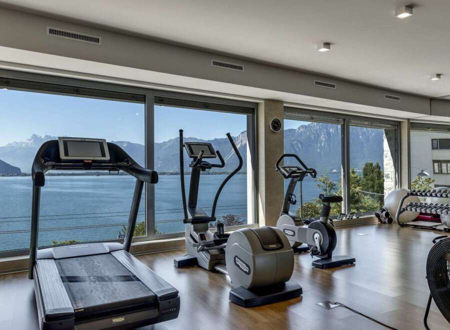 Experience the ultimate fitness retreat in this stunning property! This gym boasts state-of-the-art equipment, including a treadmill, elliptical, and stationary bike, all while offering breathtaking views of the surrounding landscape.