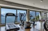 Experience the ultimate fitness retreat in this stunning property! This gym boasts state-of-the-art equipment, including a treadmill, elliptical, and stationary bike, all while offering breathtaking views of the surrounding landscape.