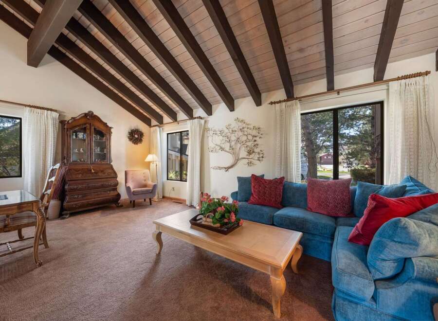 Step into this inviting living space, featuring a stunning vaulted ceiling with exposed beams.
