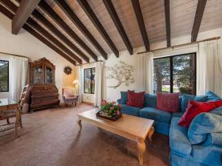 Step into this inviting living space, featuring a stunning vaulted ceiling with exposed beams.