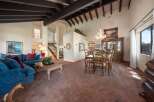 Step into luxury with this stunning property, showcasing a spacious living area with high ceilings and exposed beams.