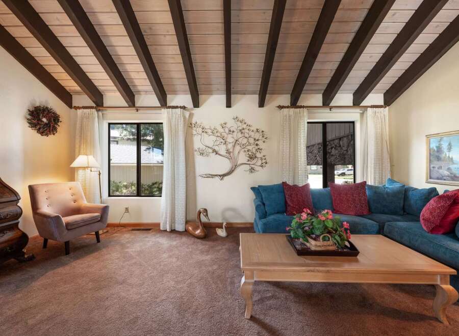Step into this inviting living space, featuring a stunning wood-beamed ceiling and a cozy ambiance.