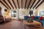Step into this inviting living space, featuring a stunning wood-beamed ceiling and a cozy ambiance.