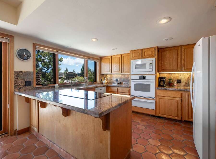 This stunning kitchen boasts a spacious island with a sleek countertop, perfect for meal preparation and entertaining.