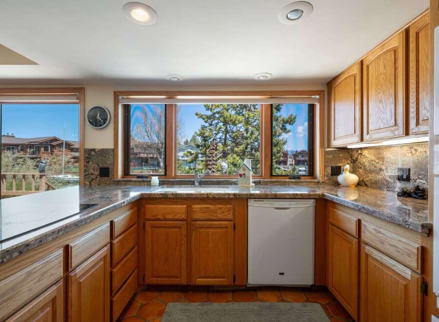 This stunning kitchen boasts beautiful wooden cabinetry and granite countertops, creating a warm and inviting atmosphere.