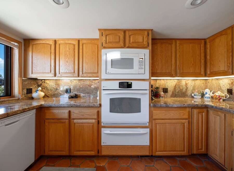 This stunning kitchen boasts beautiful wooden cabinetry and a modern appliance suite.
