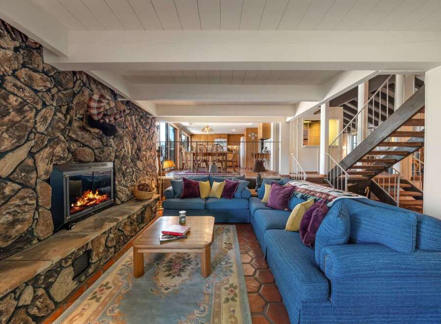 This stunning living room boasts a cozy fireplace with a stone facade, perfect for chilly evenings.