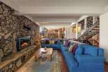This stunning living room boasts a cozy fireplace with a stone facade, perfect for chilly evenings.