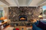 Experience the warmth of this stunning property, featuring a rustic stone fireplace as the centerpiece of the living area.
