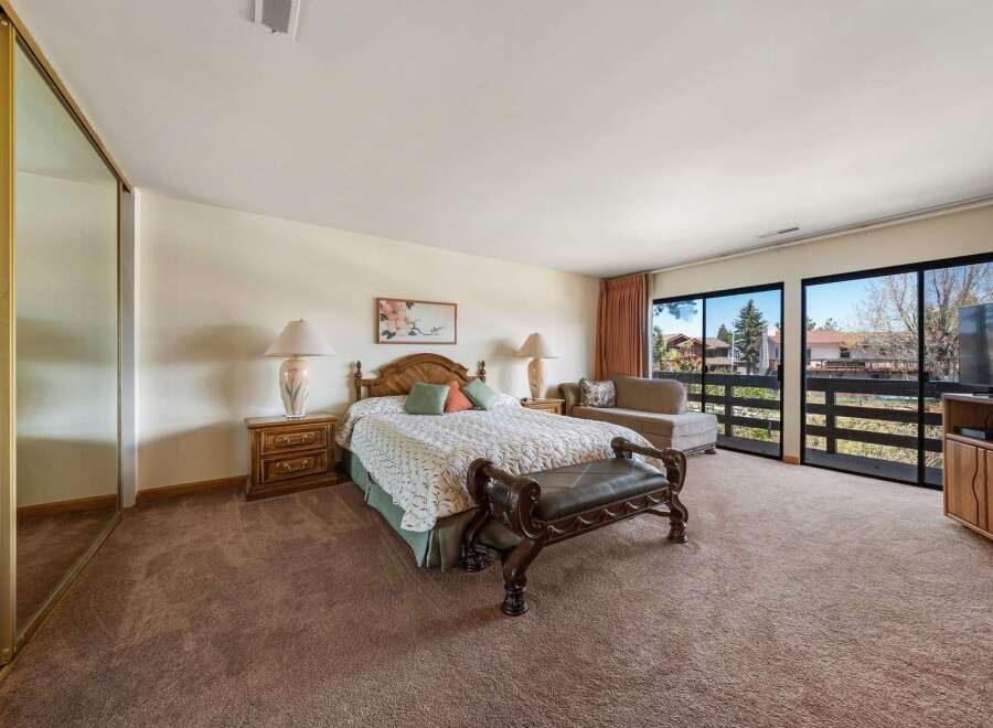 Step into luxury with this spacious bedroom featuring a comfortable bed, elegant nightstands, and a stylish bench.