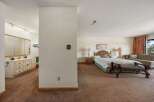 Step into this inviting bedroom, featuring a cozy ambiance and ample space.
