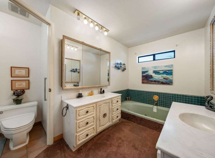 Step into this charming bathroom, featuring a vanity with ample storage and a stylish mirror.