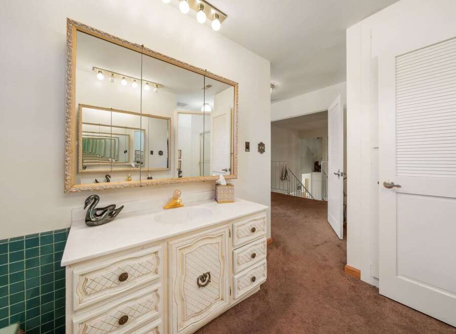 Step into this charming bathroom, featuring a vanity with ample storage and a stylish mirror.