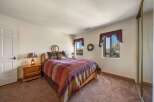 This cozy bedroom features a comfortable bed with a colorful patterned comforter, perfect for a relaxing night's sleep.