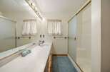 Step into this inviting bathroom featuring a spacious vanity with ample storage and a sleek design.