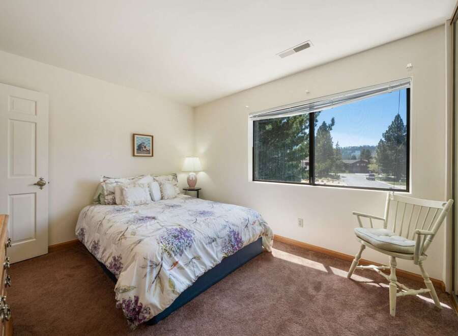This inviting bedroom features a comfortable bed with floral bedding, perfect for a relaxing retreat.