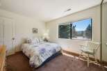 This inviting bedroom features a comfortable bed with floral bedding, perfect for a relaxing retreat.