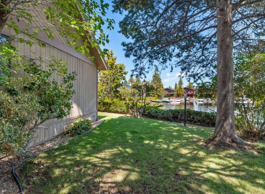 Discover waterfront living at its finest! This stunning property boasts a lush green lawn, mature trees, and direct access to the water.