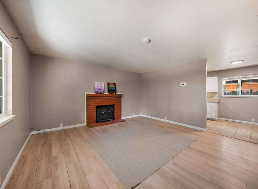 This inviting living space features a cozy brick fireplace, perfect for those chilly evenings.