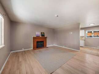 This inviting living space features a cozy brick fireplace, perfect for those chilly evenings.