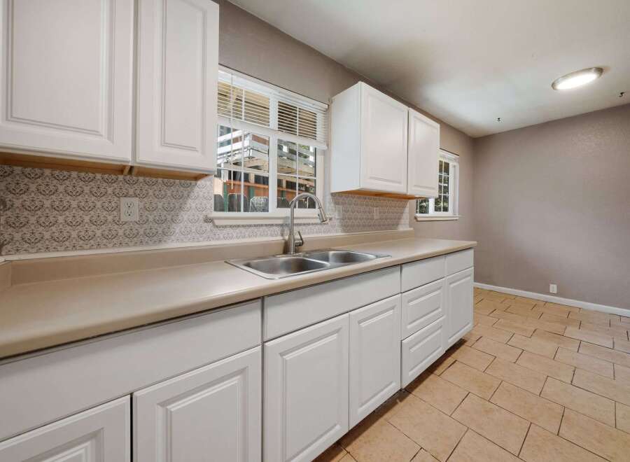 This charming kitchen boasts bright white cabinetry and a neutral countertop, creating a clean and inviting space.