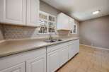 This charming kitchen boasts bright white cabinetry and a neutral countertop, creating a clean and inviting space.