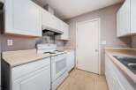 This kitchen features bright white cabinetry and appliances, creating a clean and inviting atmosphere.