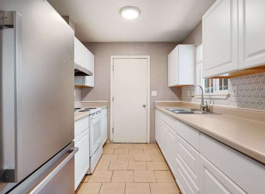 Step into this bright and inviting kitchen, featuring pristine white cabinetry and ample counter space.