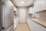 Step into this bright and inviting kitchen, featuring pristine white cabinetry and ample counter space.