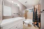 This bathroom features a bright and airy design with a clean white vanity and a large mirror.