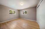 Step into this inviting bedroom, featuring natural light streaming through two windows, offering a serene view.