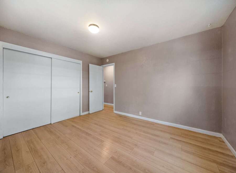 This inviting bedroom features a neutral color palette, creating a serene and adaptable space.