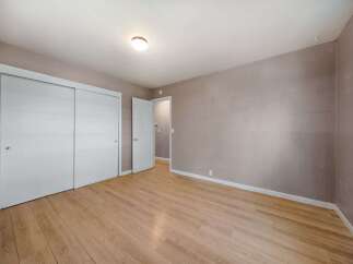 This inviting bedroom features a neutral color palette, creating a serene and adaptable space.