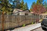 Discover the charm of this inviting property, featuring a well-maintained wooden fence adorned with festive lights.
