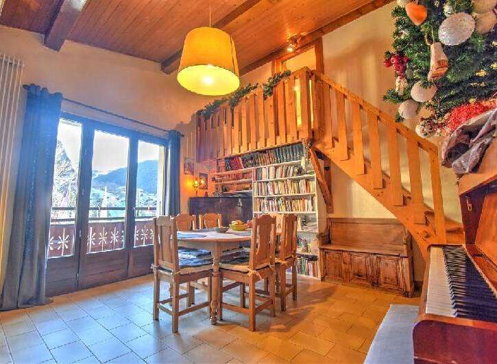 Discover the charm of this inviting property, featuring a cozy dining area with a wooden table and chairs, perfect for gatherings.