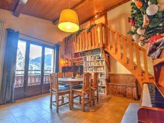 Discover the charm of this inviting property, featuring a cozy dining area with a wooden table and chairs, perfect for gatherings.